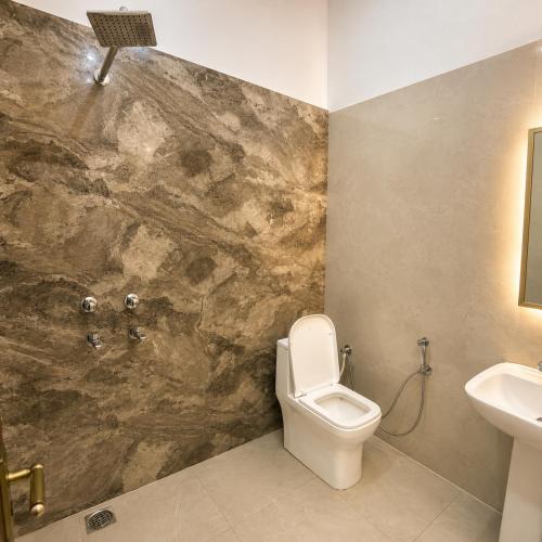 a bathroom with a toilet and a sink at Amrit Farm in Rāi