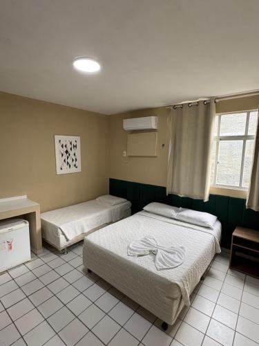 a bedroom with two beds in a room at Hotel Coqueiral in Recife