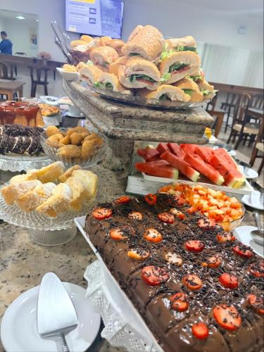 a table filled with different types of pastries and cakes at Hotel Itajaí Tur - Itajaí Navegantes in Itajaí