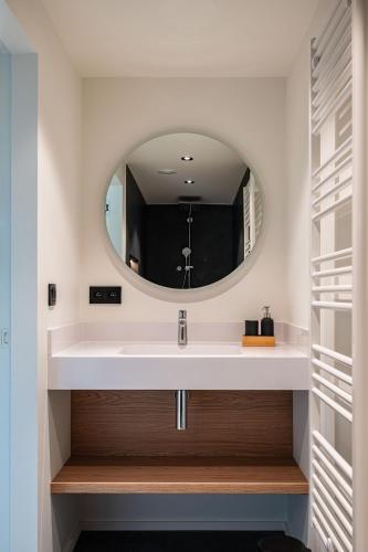 a bathroom with a white sink and a mirror at Gîte de Thibautienne in Gedinne