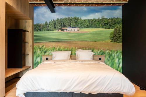 a bedroom with a bed with a painting of a golf course at Gîte de Thibautienne in Gedinne