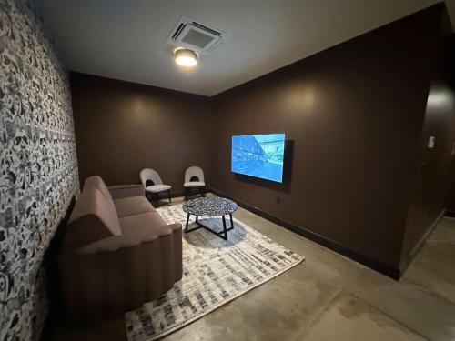 a living room with a couch and a tv at A12 Gallant Fox B02 Suite in Louisville
