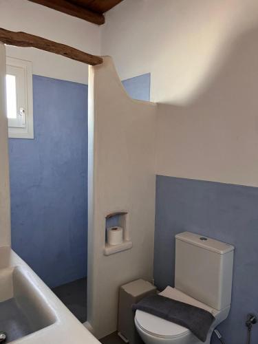 a bathroom with a white toilet and a sink at KOLOMBA GUESTS House in Vrachonisída Skylonísi