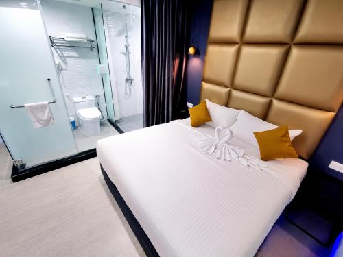 a bedroom with a large white bed and a bathroom at Hotel Wow Penang in George Town