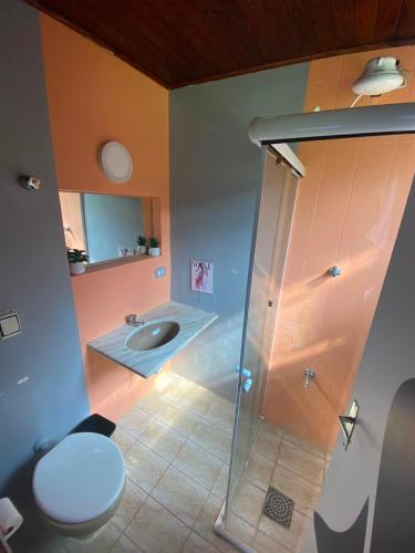 a bathroom with a shower and a sink and a toilet at Pousada 4 Elementos Guaruja in Guarujá