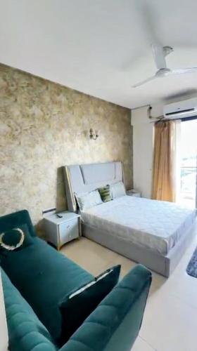 a bedroom with a large bed and a couch at Omaxe Hazratganj Stay in Lucknow