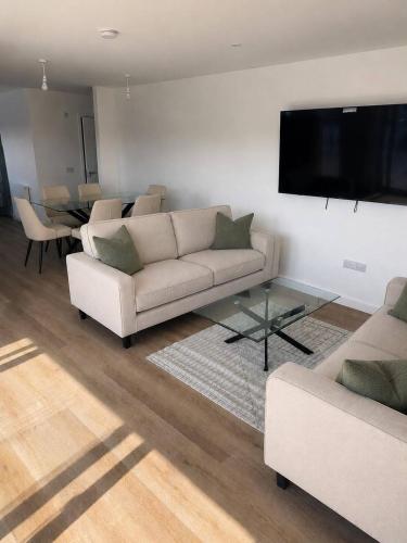 a living room with two couches and a flat screen tv at Dalhousie Residences in Carnoustie