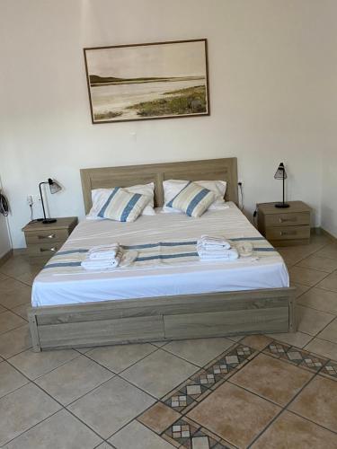 a bedroom with a large bed with two night stands at Stella's House in Mytilinioí