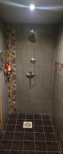 a shower in a bathroom with a tile floor at Willa Ranna Resort in Pärnu