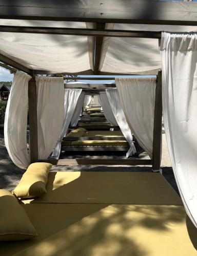 a canopy bed with white curtains in a backyard at Sevan Resort No5 in Chʼkalovka