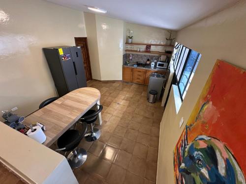 a kitchen with a wooden table and a refrigerator at Flor de Naranjo in Tabacundo