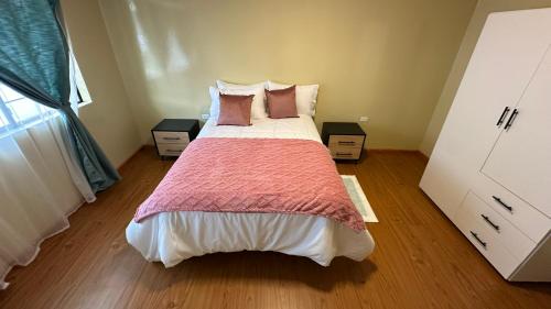 a bedroom with a large bed with two night stands at Flor de Naranjo in Tabacundo