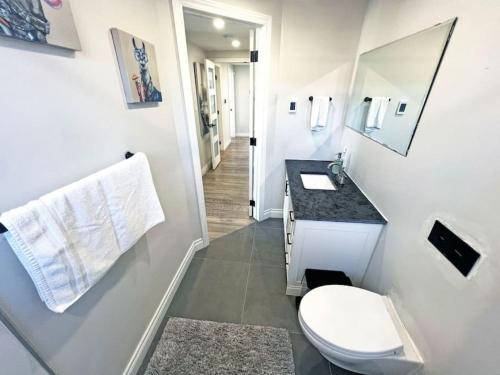a small bathroom with a toilet and a sink at Luxe Home Near Limeridge - Sleeps 11 - Pool in Hamilton