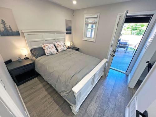 a bedroom with a bed and a door to a balcony at Luxe Home Near Limeridge - Sleeps 11 - Pool in Hamilton