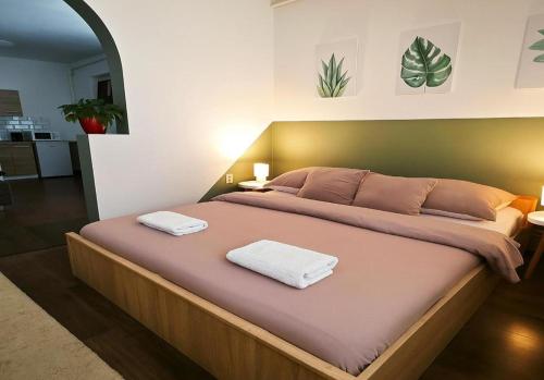 a bedroom with a large bed with two towels on it at Zöld Sziget Üdülőház in Egerszalók