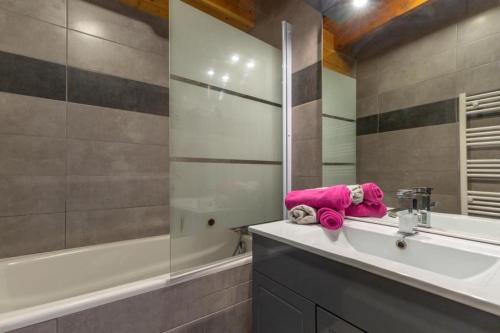 a bathroom with a sink and a tub and a mirror at Les Balcons de St So Appartement A in Saint-Sorlin-dʼArves