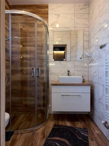 a bathroom with a shower and a sink at Domek na Hubce 2 Blisko jeziora Velo Czorsztyn in Maniowy