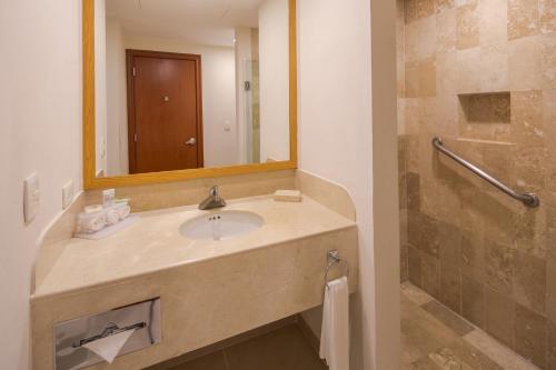 a bathroom with a sink and a mirror at Wyndham Garden Playa del Carmen in Playa del Carmen