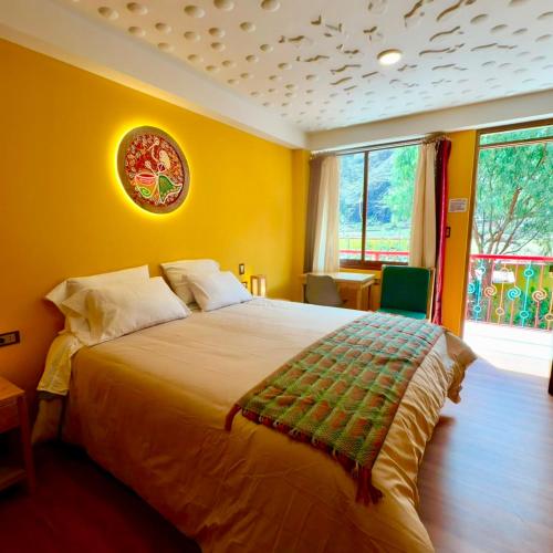 a bedroom with a large bed with yellow walls at Pisac Inca Guest House in Pisac