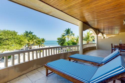 a porch with blue lounge chairs and the ocean at Beachfront 2BR Villa with Pool & Spacious Layout in Placencia