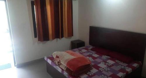 a bedroom with a bed with a quilt on it at Hotel Sunil Lodge in Gaurikund