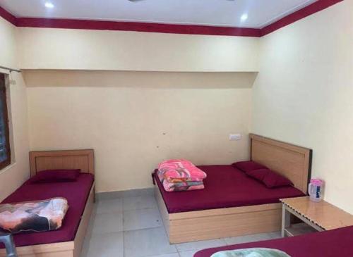 two beds in a room with purple sheets at Hotel Sunil Lodge in Gaurikund