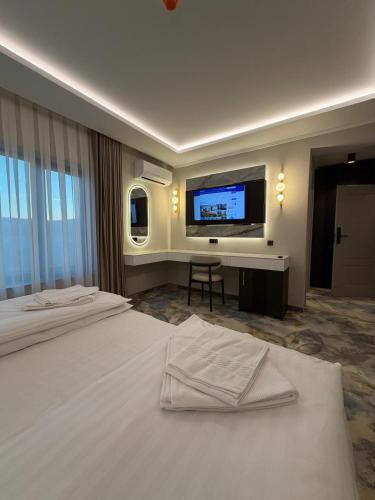 a hotel room with two beds and a flat screen tv at Pensiunea Palace in Baile Felix