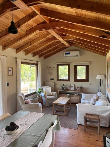 a large living room with wooden ceilings and a table at El Bosque in Trevelín