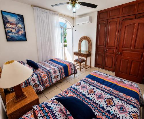 a bedroom with two beds and a dresser at Dpto Exclusive Ixtapa in Ixtapa