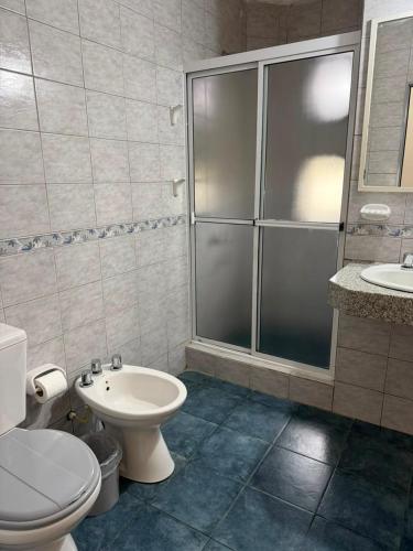 a bathroom with a shower and a toilet and a sink at Hosteria Prince in Chajarí