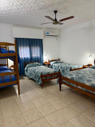 a bedroom with two beds and a ceiling fan at Hosteria Prince in Chajarí