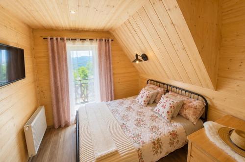 a bedroom with a bed and a window at Góralska Chatka jacuzzi in Kościelisko