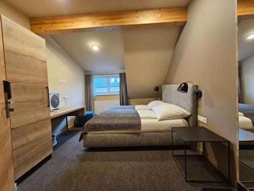 a bedroom with a bed and a desk in a room at Hotel SINOS in Klagenfurt