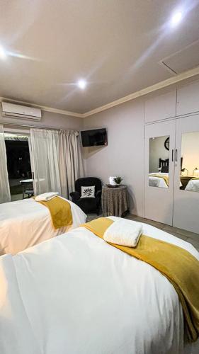 a hotel room with two beds and a chair at Nestled Peace in Klerksdorp