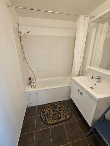 a bathroom with a bath tub and a sink at 3 pièces proche Disney in Serris