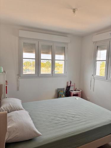 a bedroom with a large bed with two windows at 3 pièces proche Disney in Serris