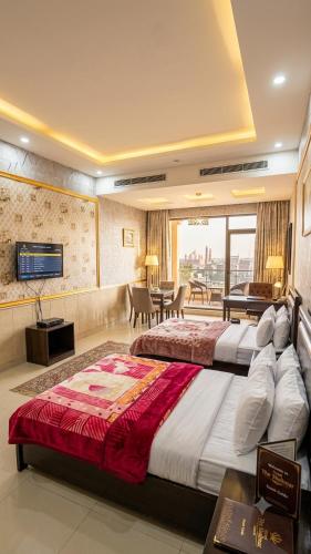 a hotel room with two beds and a living room at Hotel The Shalimar in Lahore