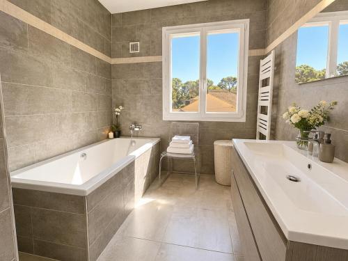a bathroom with a large tub and a sink at Haut de Villa Bianca - Spacious - Quiet in Saint-Raphaël