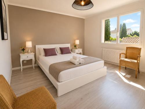 a bedroom with a bed and a chair and a window at Haut de Villa Bianca - Spacious - Quiet in Saint-Raphaël