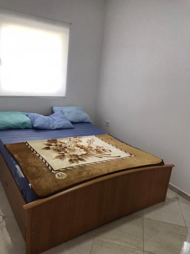 a bed with a wooden frame in a room at Apartmani Seki in Bar