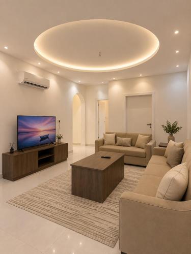a living room with couches and a flat screen tv at Comfort Stay 3 in Taif