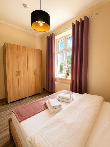 a bedroom with a large bed and a window at Apartamenty ABRACADABRA in Ustroń