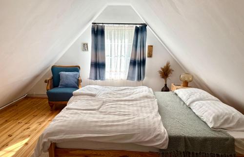 a bedroom with a bed and a blue chair at The Nook - Balatonkiliti in Siófok