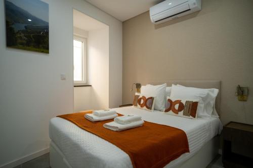 a bedroom with a bed with two towels on it at Douro River Apartment in Vila Nova de Foz Coa