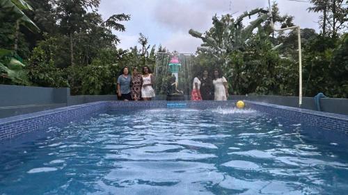 a group of women standing next to a swimming pool at Doddakallu Betta Homestay Coorg in Somvārpet