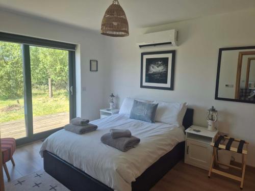 a bedroom with a bed with towels on it at Achnacolain Lodge in Tarbert