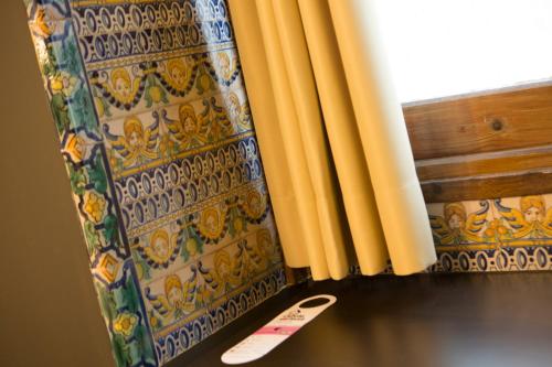 um controle remoto está sentado ao lado de uma cortina em Casual Don Juan Tenorio Sevilla em Sevilha