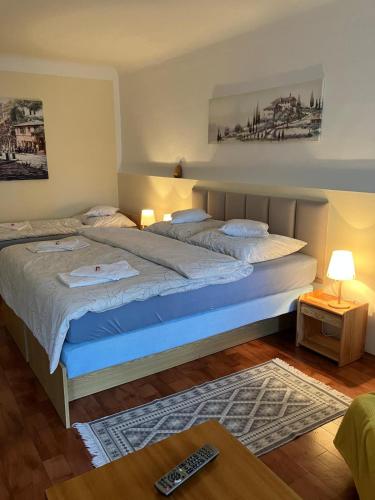a bedroom with a large bed with a remote control on it at Apartmán Pod Jánským Vrchem in Javorník