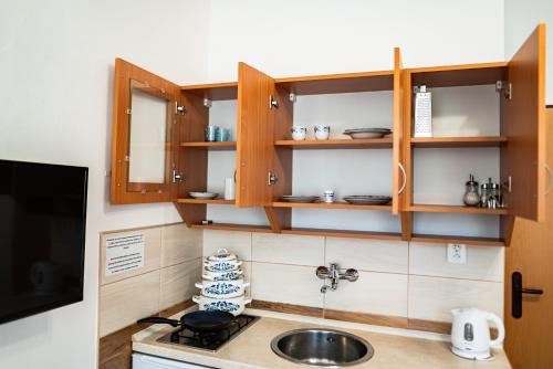 a kitchen with wooden cabinets and a sink at Pension Gábi in Františkovy Lázně