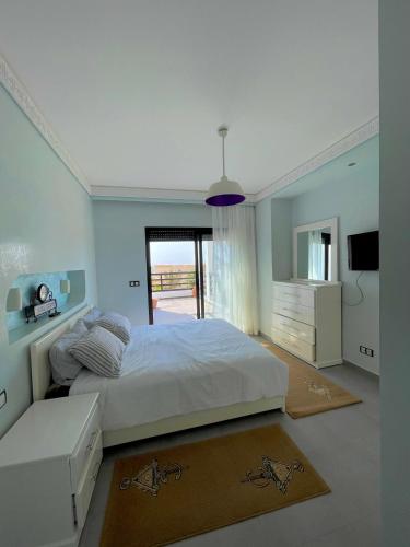 a bedroom with a large white bed and a television at VILLA EVASION Aglou Center in Zaouia Sidi Ouaggag